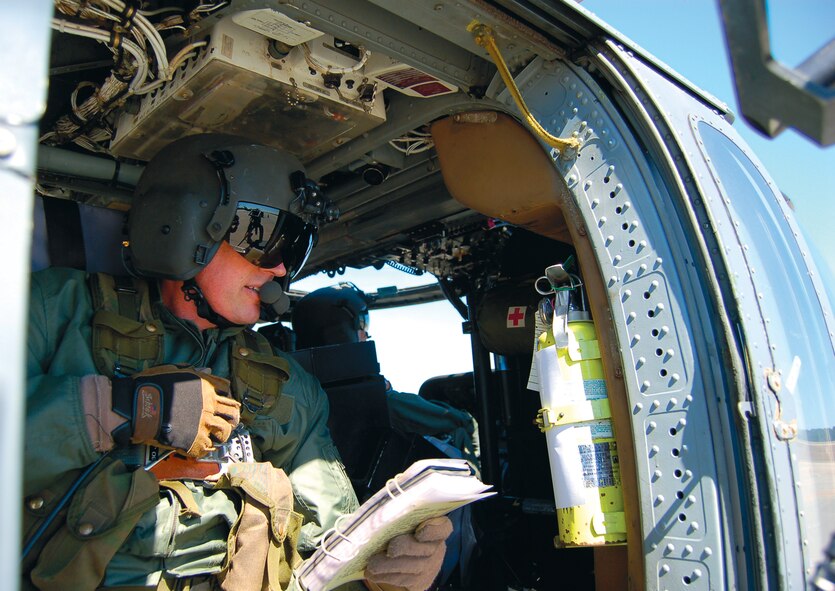 Master Sgt. John Buckler, HH-60G Pave Hawk flight engineer, reads pre-takeoff procedures to his crew during his first flight Feb. 22. Sergeant Buckler was diagnosed with cancer in 2005 and after his successful treatment, spent two years appealing to medical boards to allow him back onto flight status.  (U.S. Air Force photo by Tech. Sgt. Parker Gyokeres)

