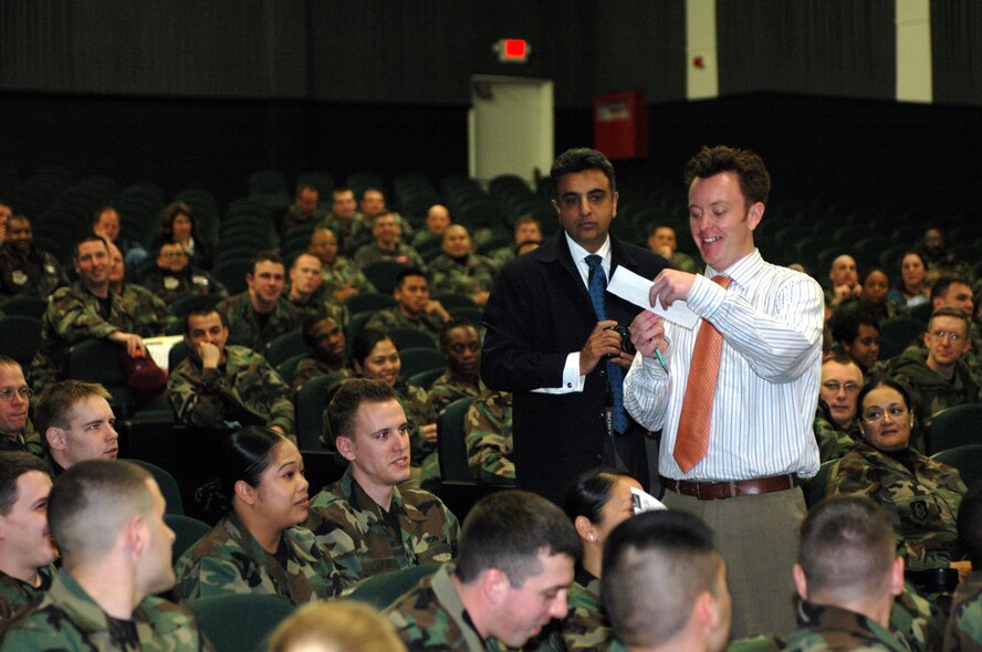Mr. Jason Gunnarson, (right), and Mr. Mustak Keval, Airmen and Family Readiness Center, hand out prizes at the base theater during the Military Saves briefing Feb. 23. The Military Saves campaign, which began Feb. 23 and ends March 2, encourages Airmen and the families to learn the importance of saving money and acquiring wealth instead of debt. (U.S. Air Force photo by Tech. Sgt. Donald Osborn)