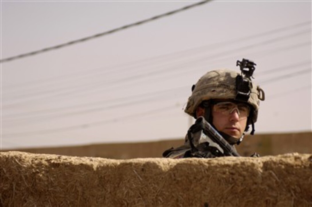 U.S. Army Pfc. Nathan Timmons scans a house during a foot patrol in Rashad village near Patrol Base Doria, Iraq, on Feb. 27, 2007.  Timmons is assigned to the 3rd Platoon, Alpha Company, 2nd Battalion, 35th Infantry Division.  