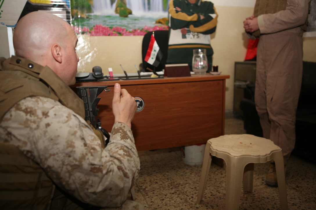 Cpl. John Szafranski, a 27-year-old Lacey Township, N.J., native and police transition team advisor with 3rd Battalion, 14th Marine Regiment, speaks to Lt. Waleed and an Arabic translator during a meeting to discuss future operations of the detective bureau of the Fallujah Iraqi Police. The detective bureau, officially the Major Crimes Unit, is responsible for investigating each arrest made by Iraqi Police in the city in order to send the suspects to trial. Having judges at the bench, something taken for granted in the United States, is focus of efforts for the II Marine Expeditionary Force and Regimental Combat Team 6 rule of law teams.