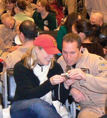Capt. Brent Stark, 8th Airlift Squadron, and his girlfriend share a laugh at the passenger terminal while looking at digital photos before the 8th AS deployment Saturday. Captain Stark is serving as an aircraft commander while deployed. (U.S. Air Force Photo by Capt. Matthew Purdiak)
