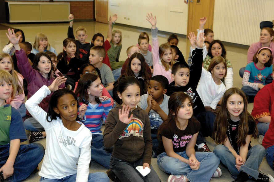 A group of children from Carter Lake Elementary school raise their hands on Feb. 21 after being asked questions regarding dental hygiene.(U.S. Air Force photo by Abner Guzman) 