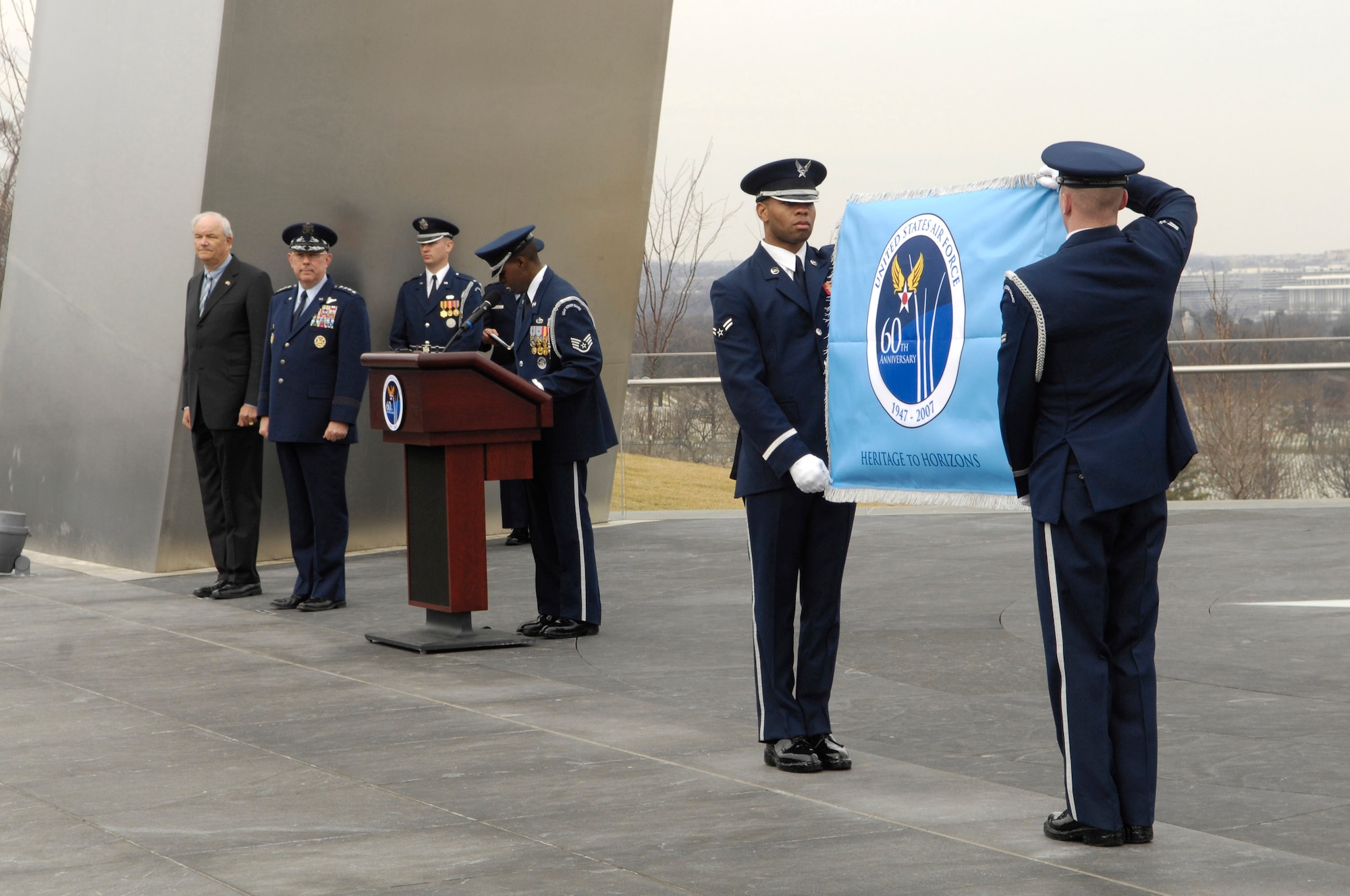 Secretary of the Air Force Michael W. Wynne and Air Force Chief of Staff Gen. T. Michael Moseley observe as Airmen from the U.S. Air Force Honor Guard display the Air Force's 60th Anniversary flag during a ceremony at the Air Force Memorial March 1 in Arlington, Va. The flag will fly at the memorial until the Air Force's 60th birthday Sept. 18.  (U.S. Air Force photo/Senior Airman Daniel R. DeCook)