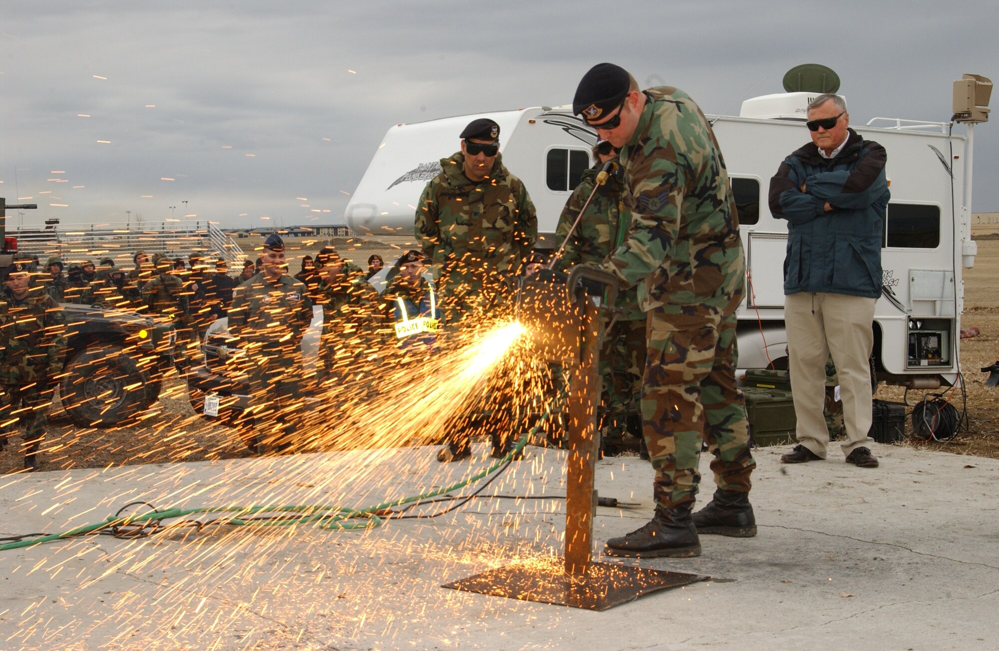 Staff Sgt. Clay Thomas, a member of the Tactical Response Force, demonstrates breaching capabilities to retired Gen. Eugene Habiger while Col. Steve Asher, 341st Security Forces Group commander, and Col. Sandy Finan, 341st Space Wing commander, look on. 
