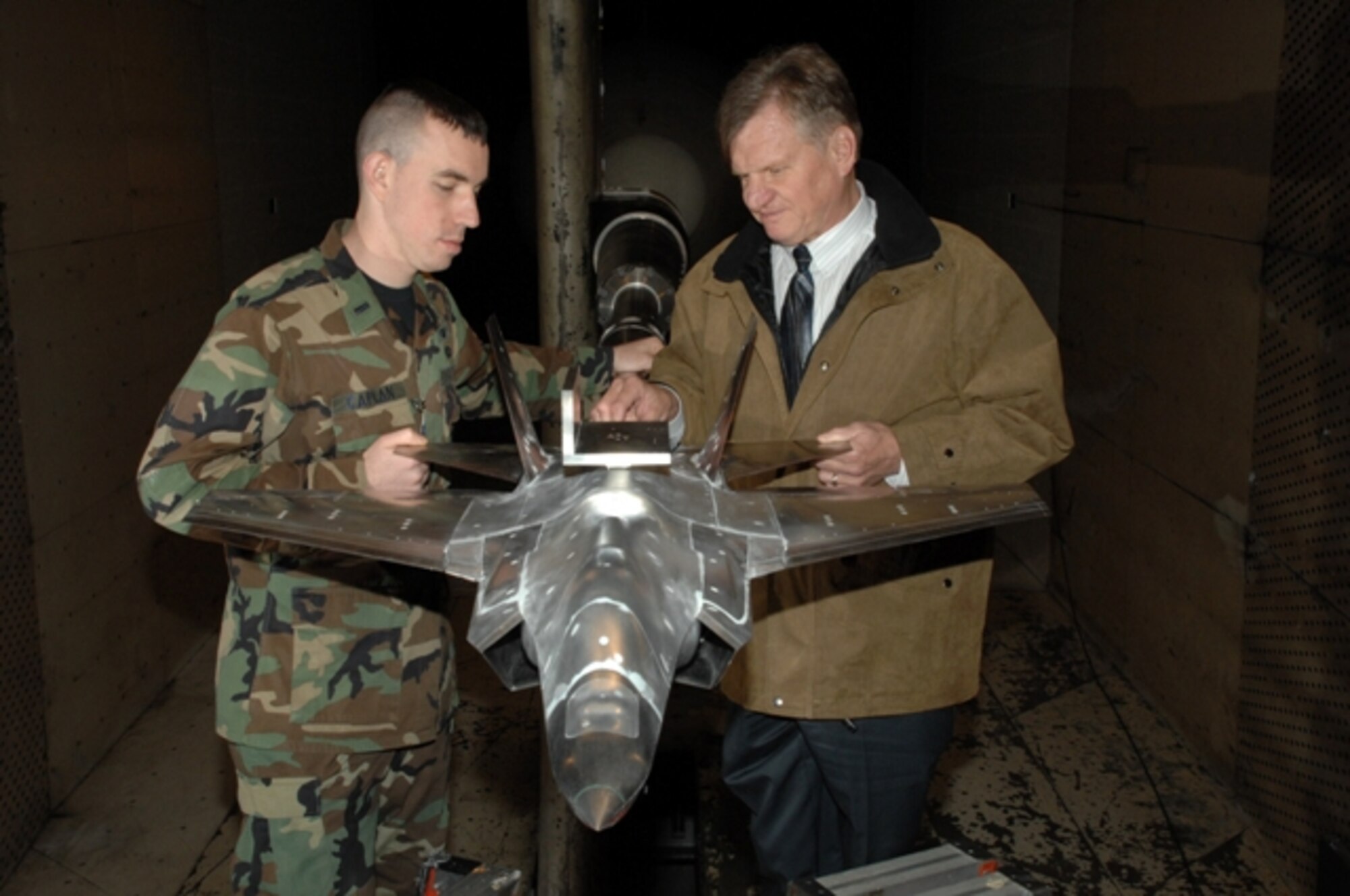 First Lt. Ezra Caplan and Aerospace Testing Alliance Senior Project Engineer Charlie Smith examine a 1/12th scale model of the Navy variant of the F-35 Lightning II during a break in the final pre-production aerodynamics testing done on all F-35 variants here at Arnold Engineering Development Center, Arnold Air Force Base, Tenn. (Photo by Rick Goodfriend)