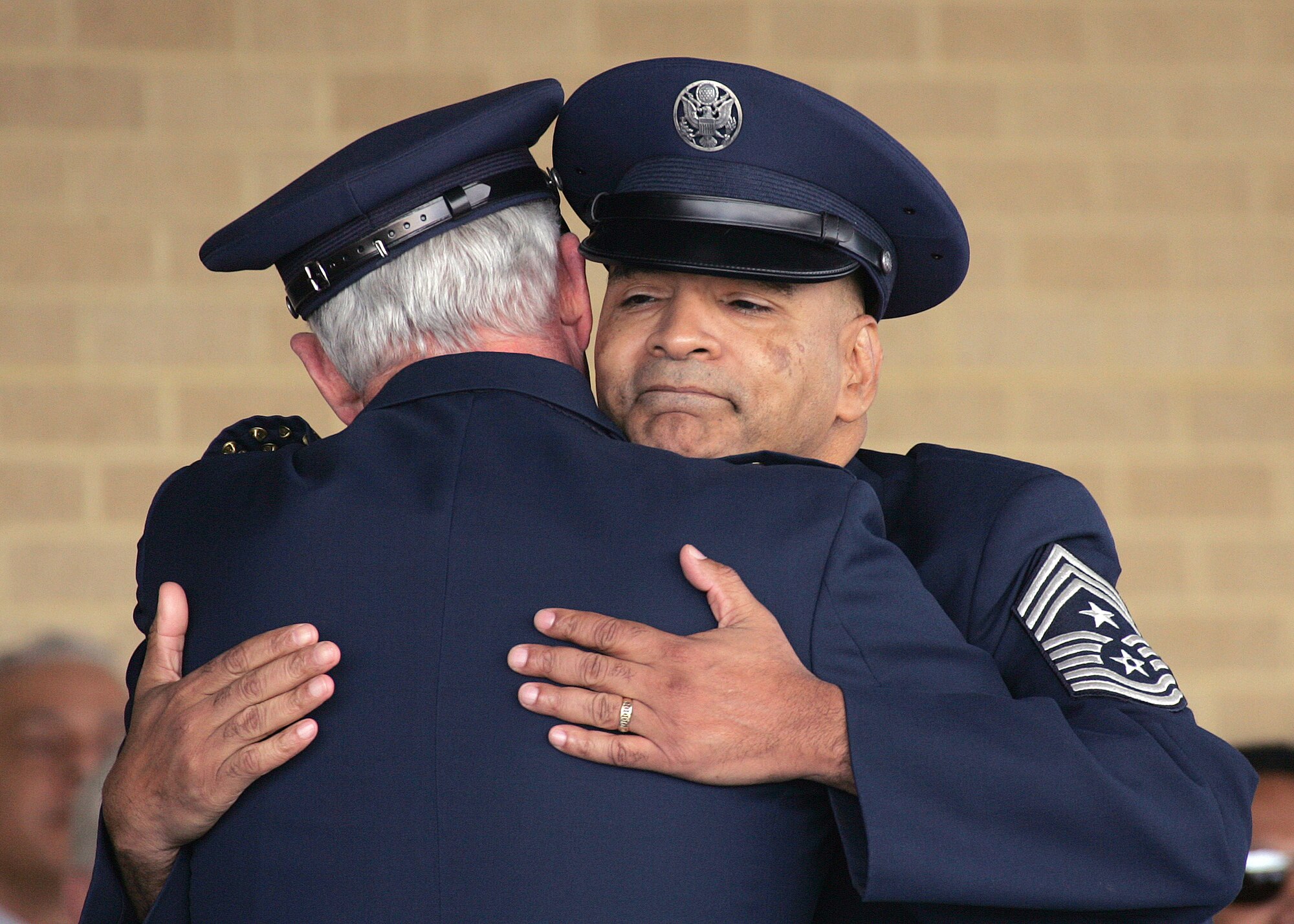 The retiring command chief master sergeant of Air Education and Training Command, Chief Master Sgt. Rodney E. Ellison, receives a heartfelt hug from Gen. William R. Looney III, AETC commander, while in the reviewing stands at the basic military training graduation parade March 2 on Lackland Air Force Base, Texas. (Air Force photo by Robbin Cresswell)
