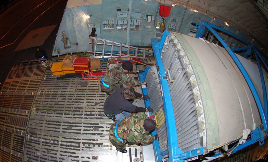 DOVER AIR FORCE BASE, Del. -- (Top to bottom) Airman 1st Class Jonathon Brown, Mr. Donald Krauss and Staff Sgt. Ozvardo Taylor, 436th Aerial Port Squadron Ramp Rervices, pull Royal Air Force C-130 wings into position aboard C-5 destined for the United Kingdom. The wings are the first of two sets that were purchased by the RAF from the Royal Australian Air Force and will be used to refurbish operational C-130s in the UK. (U.S. Air Force Photo/Tech. Sgt. Kevin Wallace)