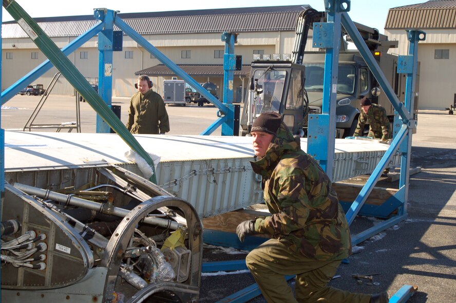 DOVER AIR FORCE BASE, Del. -- Cpl. Derek Moir, Royal Air Force St. Athan air frame technician, looks to crane operator Master Sgt. Rick Veller, Air Mobility Command Museum operations NCO, who is lowering a C-130 wing. The 436th Aerial Port Squadron, Air Mobility Command Museum and the RAF teamed up to airlift the wings, which the RAF purchased from the Royal Australian Air Force, to the UK to refurbish an operational C-130 there. (U.S. Air Force photo/Tech. Sgt. Kevin Wallace)