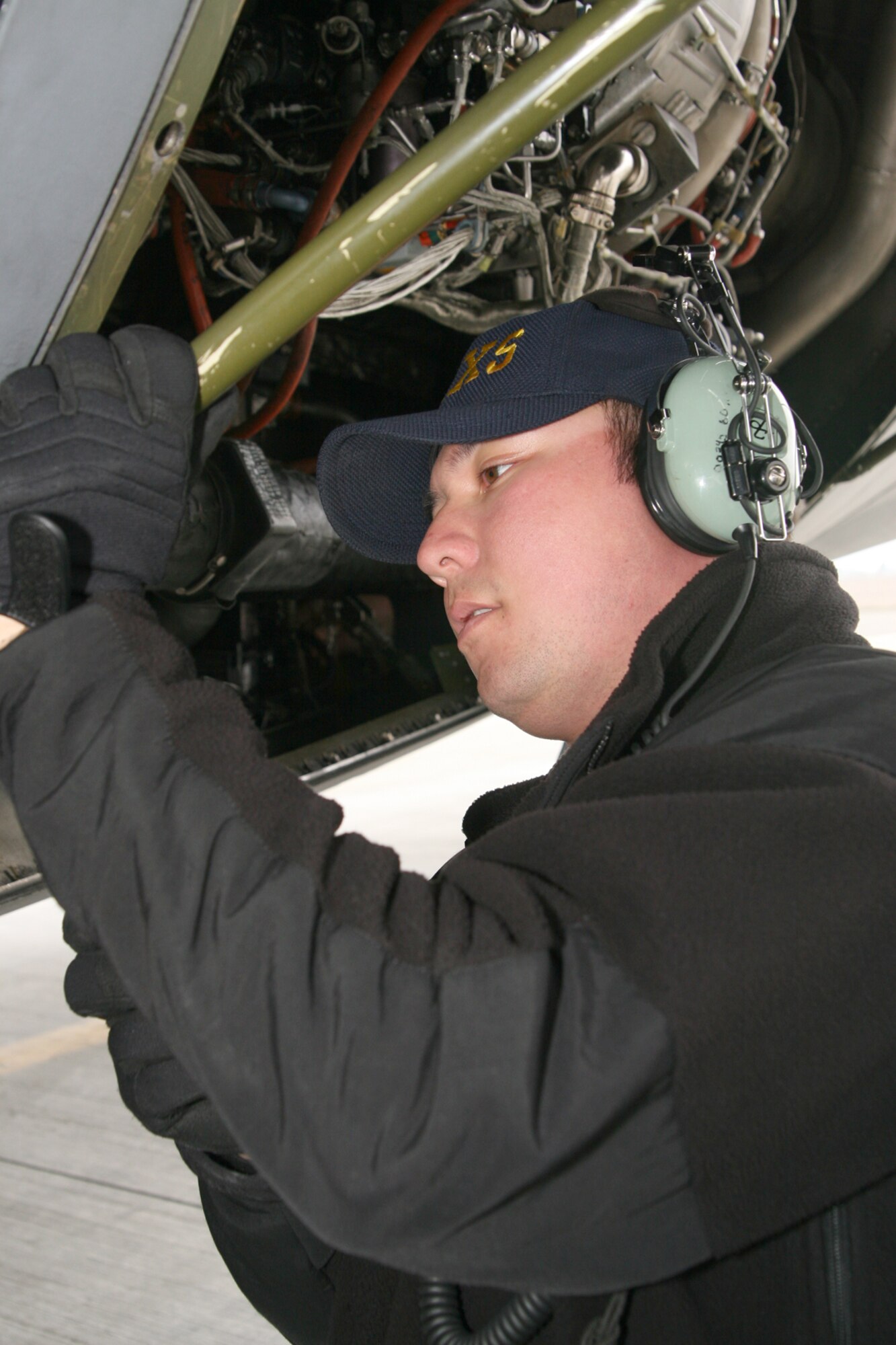 Senior Airman Steve Floyd, 60th Aircraft Maintenance Squadron C-5 Galaxy crew chief, secures the auxiliary power unit access panel in the open position to check the oil quantity in the air turbine motor, part of a routine check before the aircraft takes off. The C-5 was preparing for a mission after being loaded. The 60th AMXS and the 349th AMXS recently won the 2006 Air Mobility Command’s Maintenance Effectiveness Award, the highest command level award for aircraft maintenance squadrons. (U.S. Air Force photo by Master Sgt. Wendy Weidenhamer)