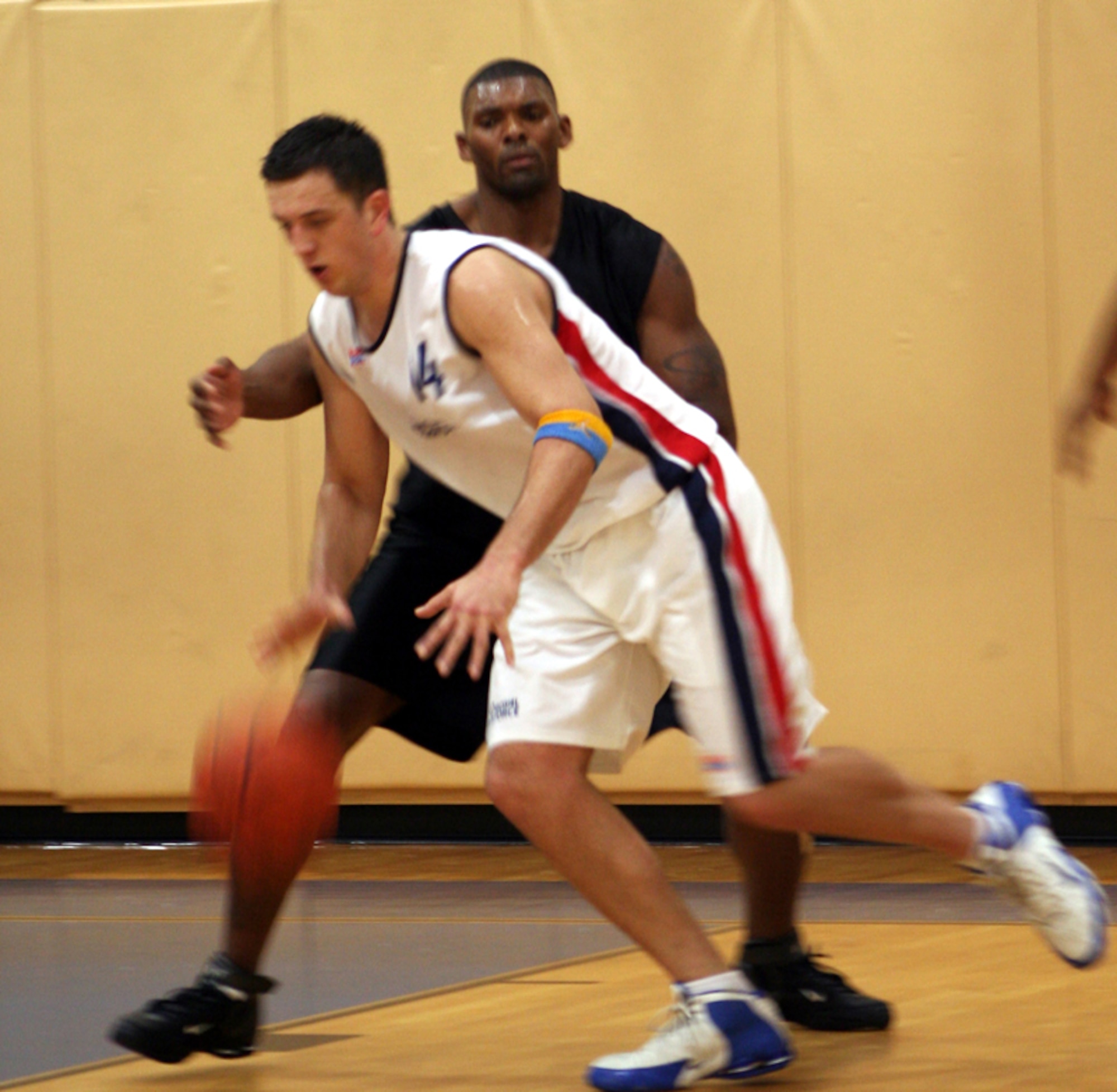 Commando Jammar Major (in black) attempts to steal the ball from a Royal Air Force player during an exhibition game Feb. 22 in the Commando Fitness Center. (U.S. Air Force photo by Jamie Haig)