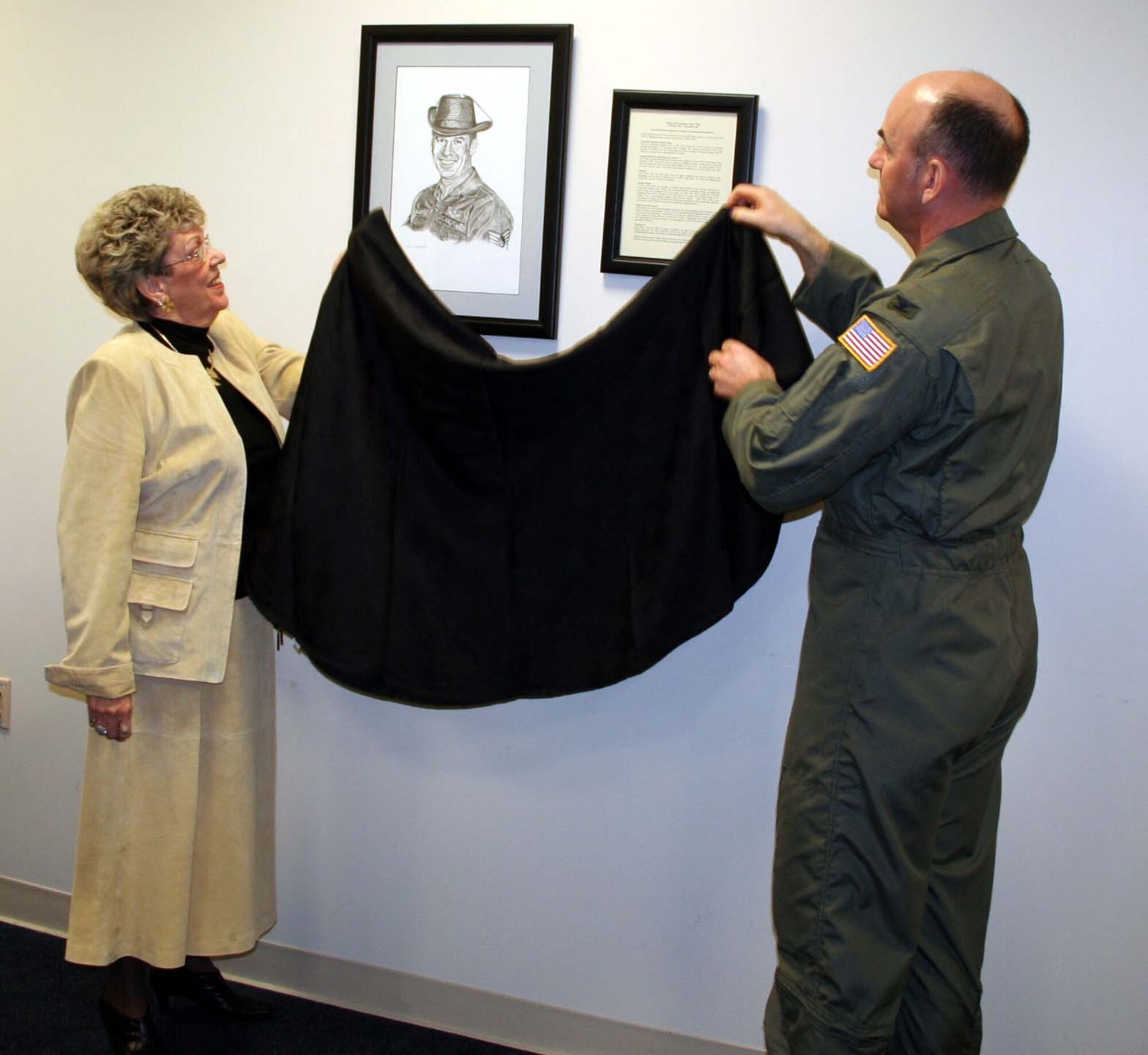 Linda Wiley helps Col. Michael Callan, Air Force Special Operations Forces commander, unveil the drawing of her husband during the dedication ceremony of the AFSOF conference room to Chief Master Sgt. Atwell Livingston "Duke" Wiley Tuesday. (U.S. Air Force photo by Jamie Haig)