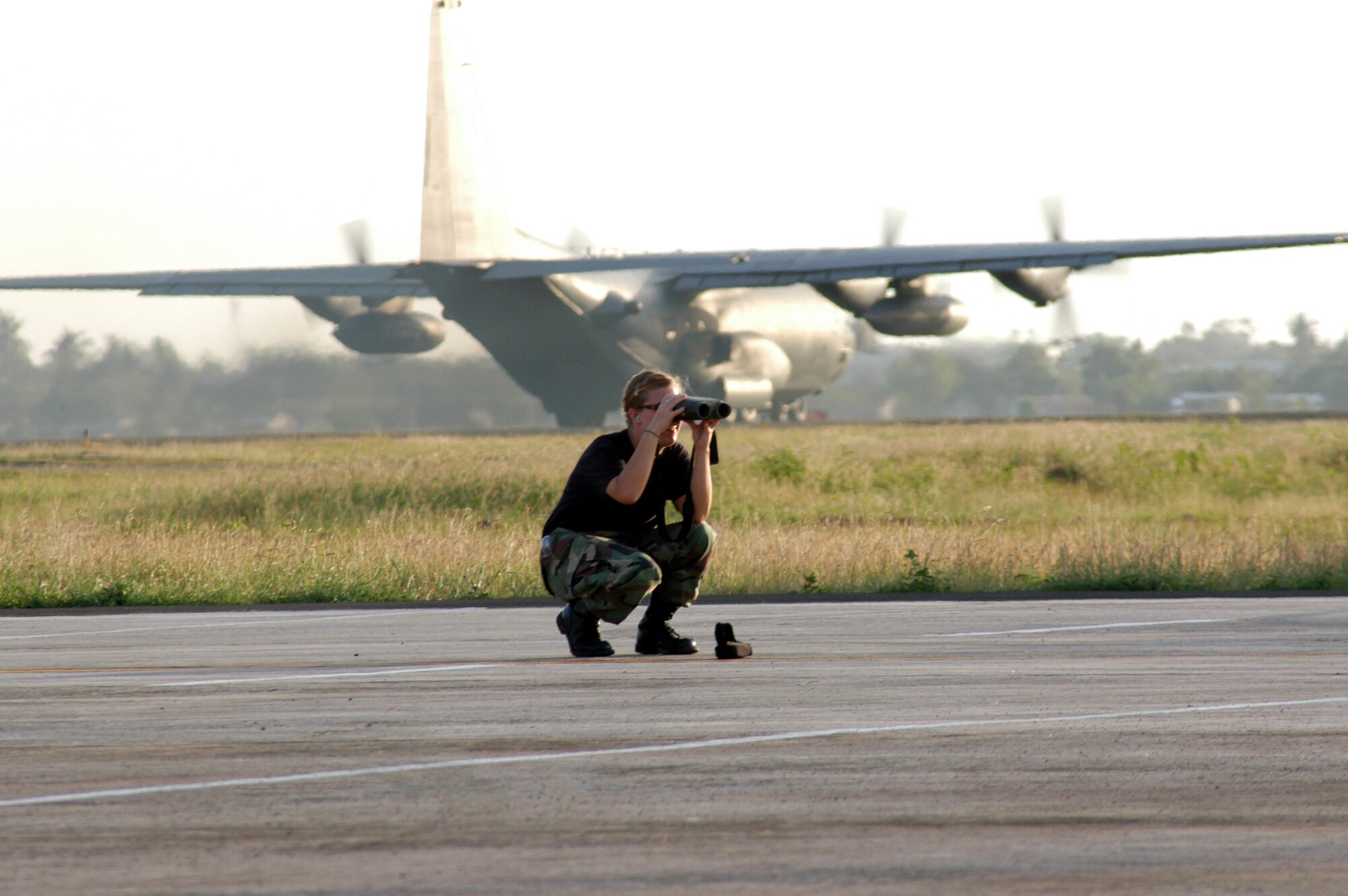 Staff Sgt. Sara Klobucar, a weather technician from the 353rd Operations Support Squadron at Kadena Air Base, Japan, uses a laser range finder to complete an airfield survey at Mactan Air Base, Philippines.  During her weather observation, she determines quadrant markers and landmarks that can be used to determine the required visibility to ensure safe flight.  In the background is a Combat Talon II, assigned to the 353 SOG and flown by members of the 1st Special Operations Squadron, also from Kadena, preparing for takeoff.  Both squadrons, part of the 353rd Special Operations Group, were participating in Balance Piston, a joint combined exchange training event at Mactan. (USAF photo by Master Sgt. Marilyn Holliday)                         