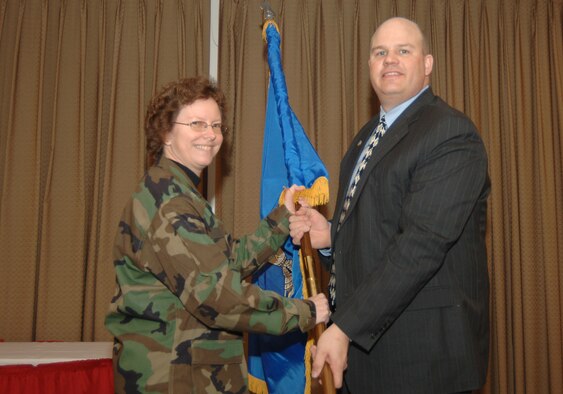 GRAND FORKS AIR FORCE BASE, N.D. -- Col. Diane Hull, 319th Air Refueling Wing commander, ceremonially passes the wing guidon to Mr. Wade Pearson, inducting him as honorary wing commander during a ceremony here, Feb. 26.  Including Mr. Pearson, two local community leaders became new honorary commanders, Rev. Paul Knight became the wing's first honorary wing chaplain, and 25 other community leaders “re-upped” for another year, some switching units. (U.S. Air Force photo/Airman 1st Class Chad Kellum)