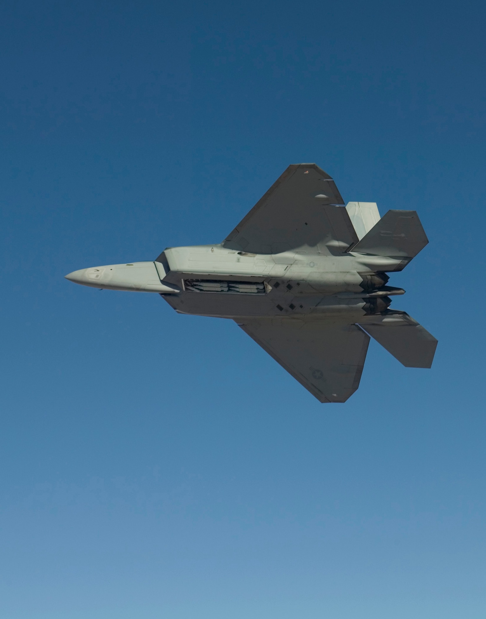 An F-22A Raptor flies Feb. 2, 2007, with four Small Diameter Bombs on board. Pilots and engineers from the F-22 Combined Test Force were performing load tests to ensure the GBU-39/B Small Diameter Bomb system does not exceed structural load boundaries for the Raptor. (Photo by Darin Russell)
