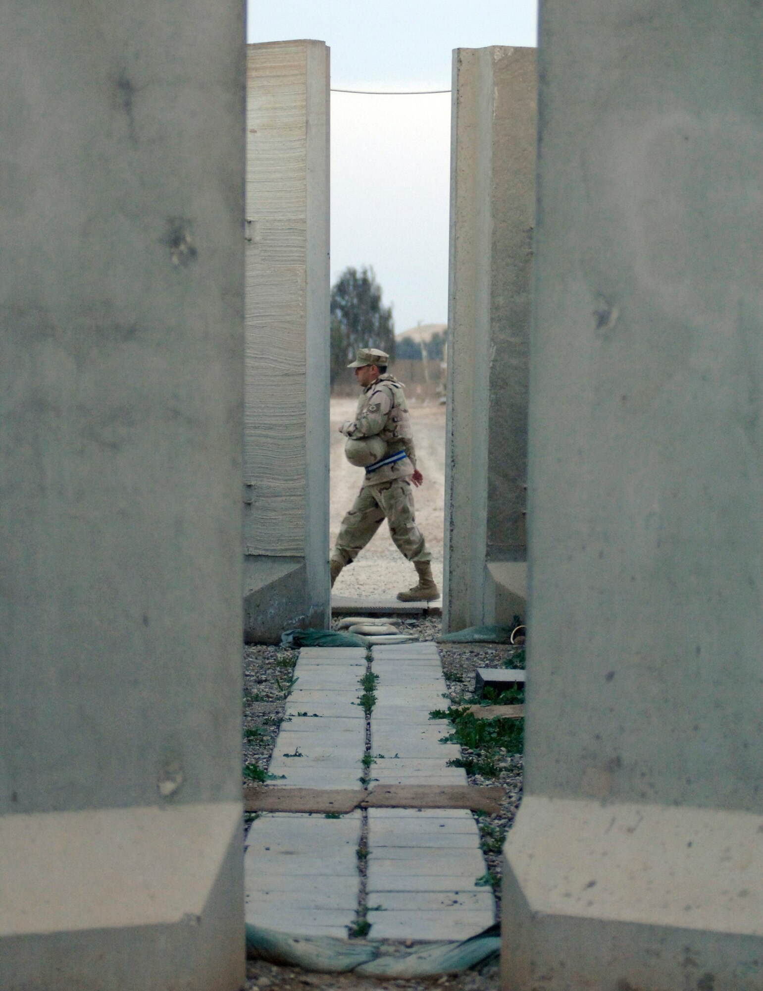 An Airman walks between a row of large T-barriers Feb. 22 at Balad Air Base, Iraq.  Most Airmen assigned to the base live in a compound surrounded by T-barriers, which act as a line of defense against stray bullets and mortar attacks. The pathways serve as a shield for more than 3,300 Airmen. (U.S. Air Force photo/Tech. Sgt. Cecilio M. Ricardo Jr.)