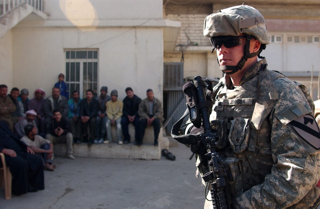 U.S. Army Staff Sgt. Adam Johnson provides security over workers from a flour factory during a raid, Feb. 27, 2007, in Mosul, Iraq. Johnson is with Delta Company, 2nd Battalion, 7th Cavalry Regiment, 4th Brigade Combat Team, 1st Cavalry Division, out of Fort Bliss, Texas.