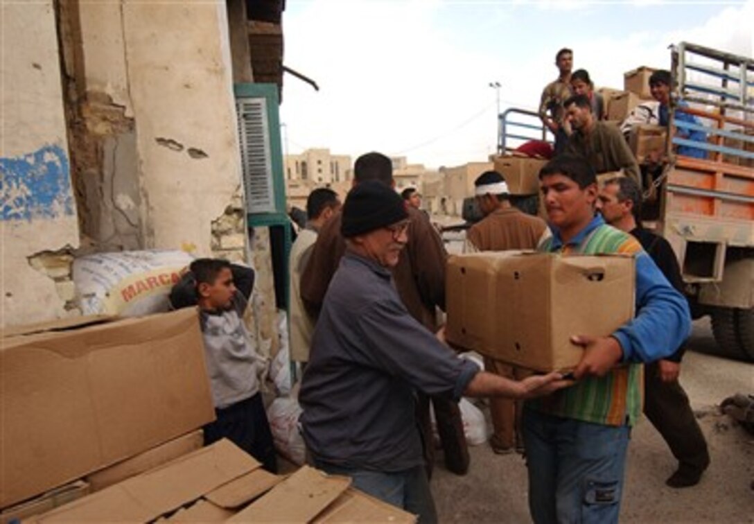 Iraqi civilians off-load food and other aid materials provided by 2nd Brigade Combat Team, 1st Cavalry Division during a humanitarian aid dropoff in Baghdad, Iraq, Feb. 26, 2007.
