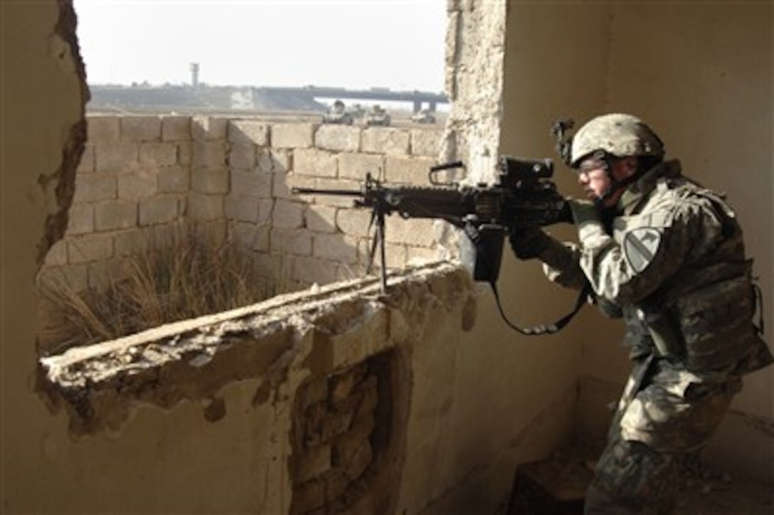 U.S. Army Spc. Brett Bell, a fire support specialist assigned to Echo Company, 2nd Battalion, 5th Cavalry Regiment, 1st Cavalry Division, searches for contacts during a cordon and search operation in western Baghdad, Iraq, on Feb. 23, 2007.  