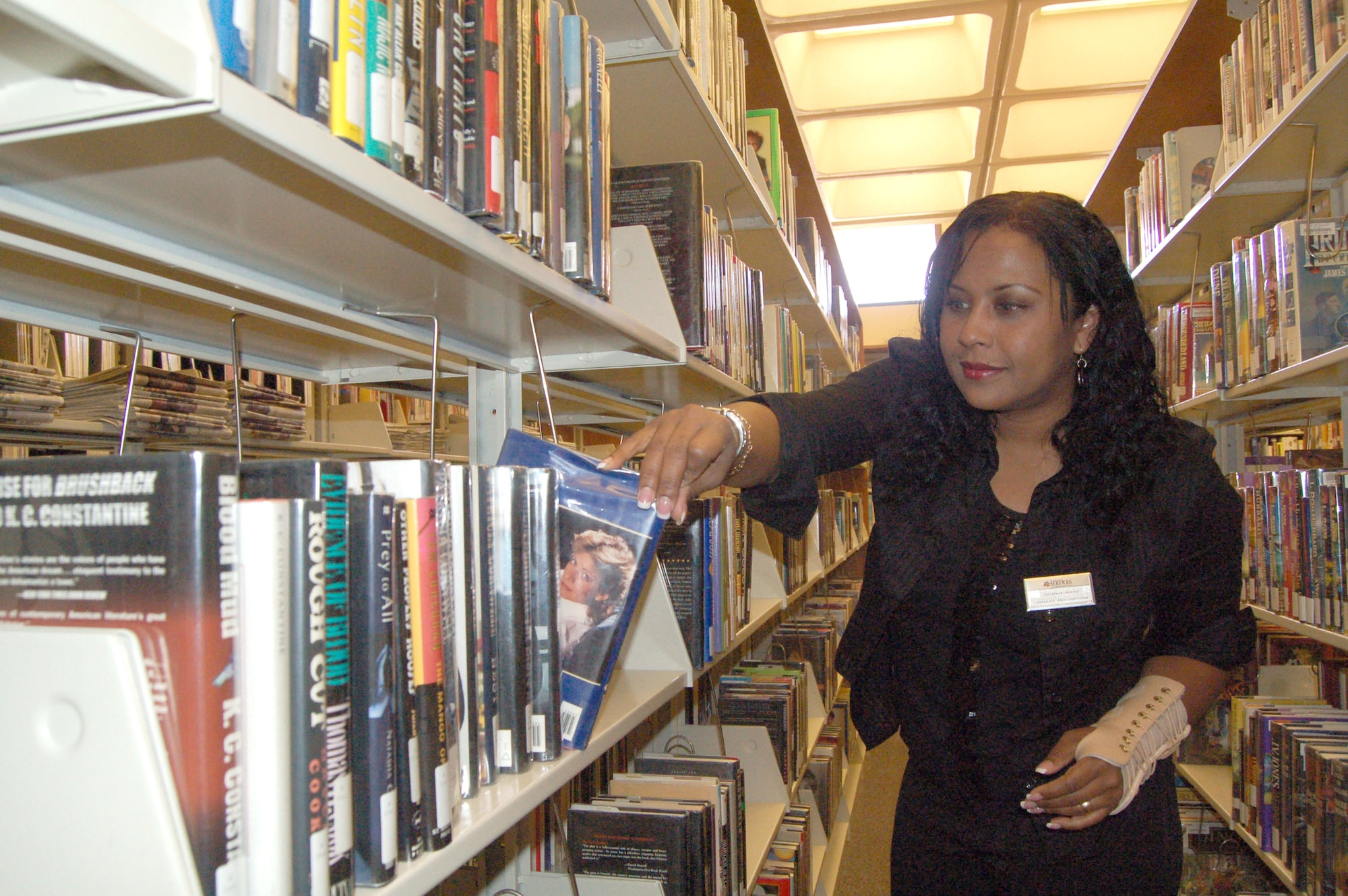Peronica Hunt organizes books on a shelf Feb. 21 at the Edwards Air Force Base, Calif., main library. The library was among 87 programs Air Force-wide achieving a Five Star rating from the Air Force Services Agency. It was the third consecutive year the distinction was earned by the Edwards Main Library, which was also the best in Air Force Materiel Command for fourth year in a row. Ms. Hunt is a library technician. (U.S. Air Force photo/Airman 1st Class Julius Delos Reyes)