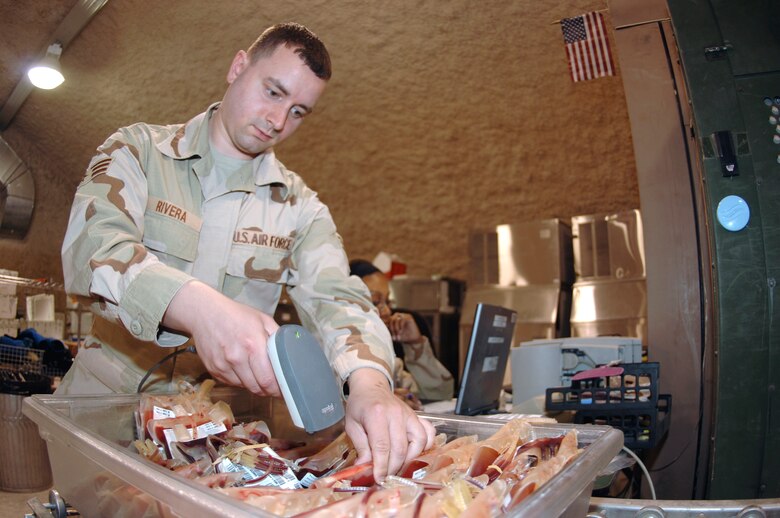 Senior Airman Samuel Rivera, 379th Expeditionary Medical Group Blood Transshipment Center administration technician, scans blood into a database, which designates which forward blood supply unit in the AOR will receive it. (U.S. Air Force photo by Staff Sgt. David Miller)