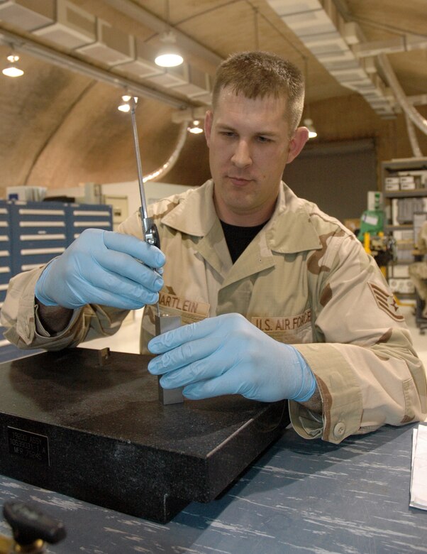 Staff Sgt. Jeffrey Hartlein, 379th Expeditionary Maintenance Squadron Test, Measurement, and Diagnostic Equipment Flight TMDE craftsman, calibrates a dial caliper used to make length or width measurements on a multitude of different parts. (U.S. Air Force photo by Senior Airman Erik Hofmeyer)