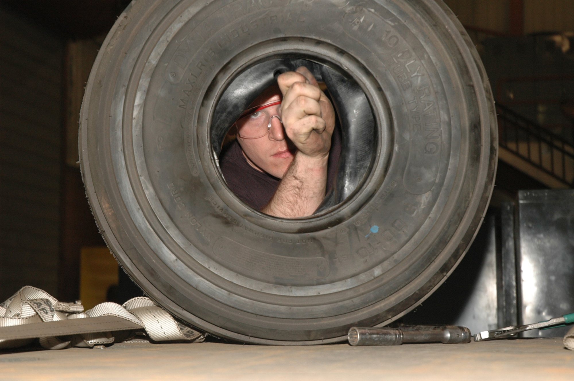 OSAN AIR BASE, Republic of Korea --  Senior Airman Donald Collins, 51st Munitions Squadron, rebuilds a tire for a Mission Handling Unit 110 Friday. The MHU-110 is a trailer used to transport bombs between the munitions squadron and the flightline. Airman Collins is a munitions support section technician here. (U.S. Air Force photo by Staff Sgt. Benjamin Rojek)