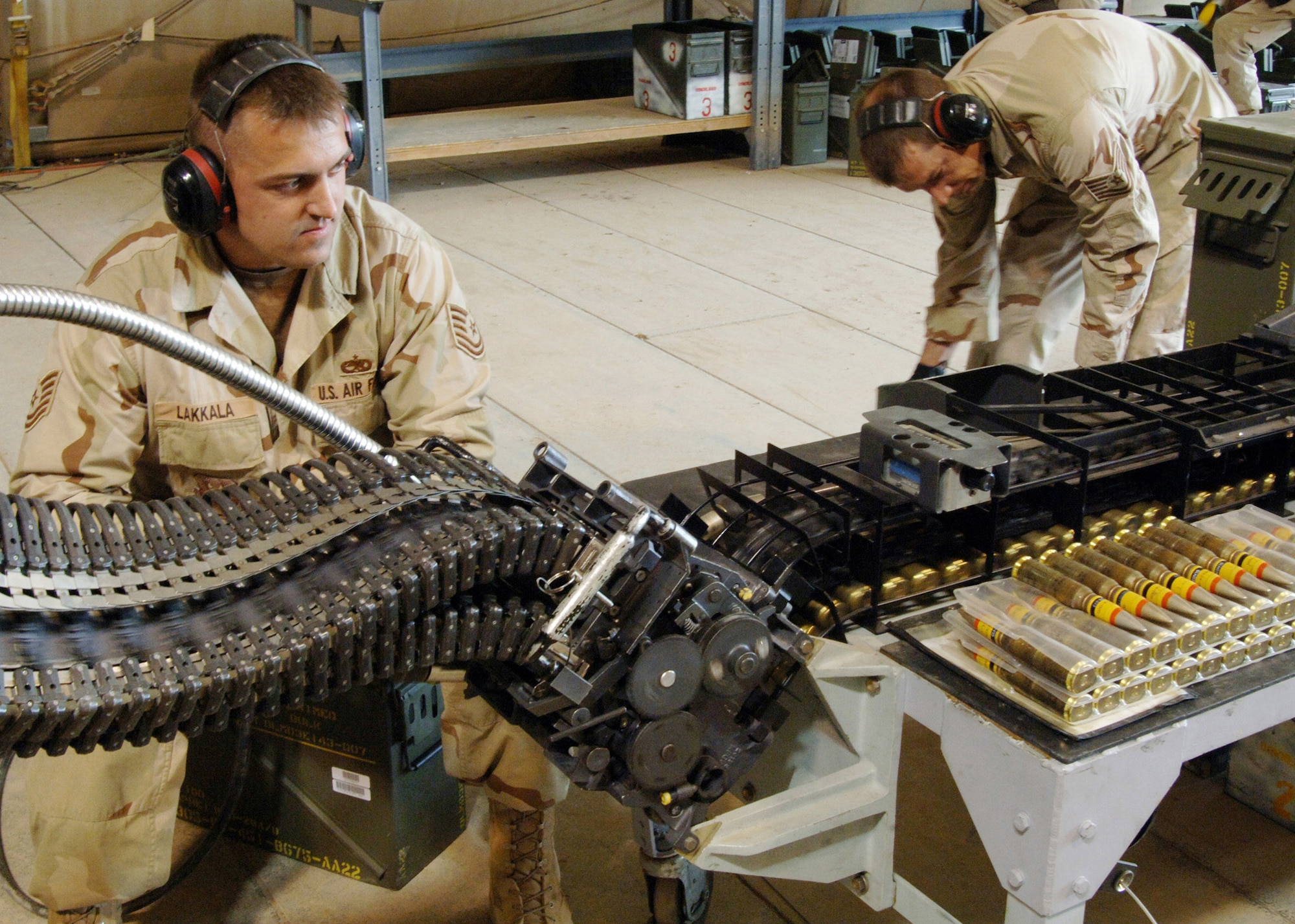 Tech. Sgt. Chris Lakkala (left) regulates the rate of operation for the replenisher tray as it feeds PGU-28A/B 20mm cannon rounds into the universal ammunition loading system while Tech. Sgt. J.C. Whitney prepares more rounds to load through the replenisher Feb. 25 at Balad Air Base, Iraq. The new ammo allows for higher velocity, a greater standoff distance and increased safety for pilots, all contributing to greater effectiveness while providing close-air support. Its use Feb. 26 against insurgents east of Baghdad, Iraq, marked the first in battle for Air Force F-16 Fighting Falcon pilots. Both Airmen are deployed from Aviano Air Base, Italy. (U.S. Air Force photo/Capt. Ken Hall)