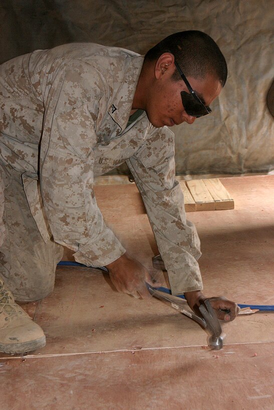 COMBAT OUTPOST ELLIS, Iraq (March 4, 2007)--Lance Cpl Jorge Vega, a supply Marines with Battalion Landing Team 2/4, and a native of McAllen, Texas, nails down the new flooring in his tent. ::n::Marines and Sailors based at COP Ellis have seen many new improvements to their living spaces in previous days to include new floors and heating and cooling units in their tents.::n::Battalion Landing Team 2/4 is currently working from COP Ellis located just outside of Barwanah, Iraq and has been conducting operations since late November.::n::BLT 2/4 is deployed to Iraq as part of the Camp Pendleton, Calif.-based, 15th Marine Expeditionary Unit.::n::(Official USMC photo by Staff Sgt TG Kessler) (Released)