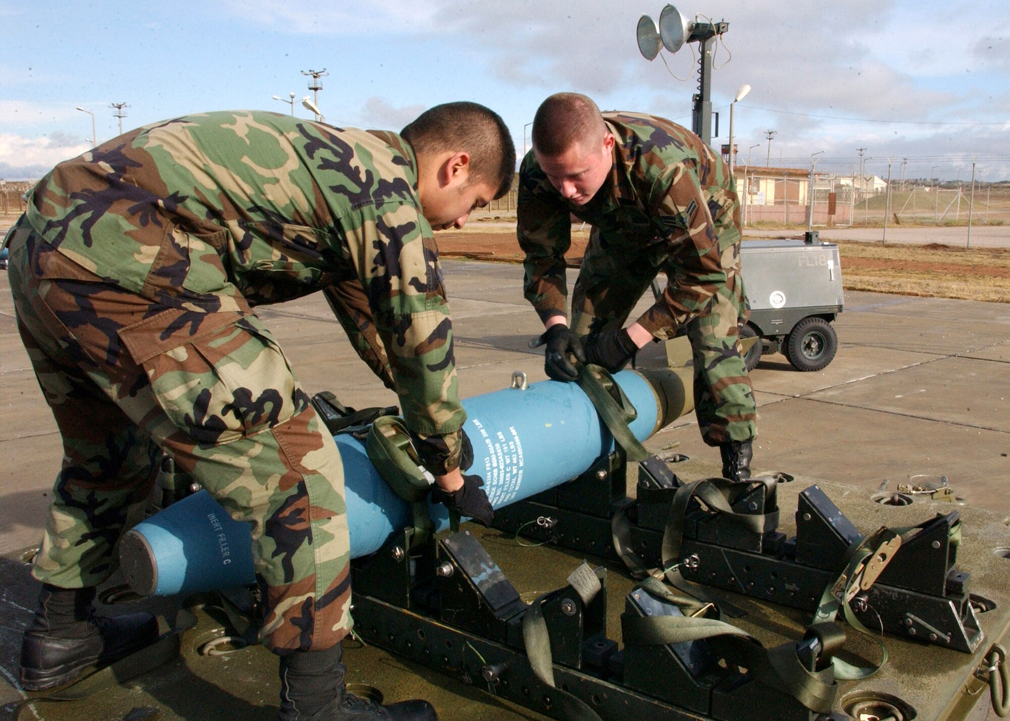 Airman 1st Class Juan Diego Hernandez and Airman 1st Class Nathan Myyra secure a test bomb to a transport trailer in February at Incirlik Air Base, Turkey. The Airmen are assigned to the 39th Maintenance Squadron and are training with Airmen and F-16 Fighting Falcons from Spangdahlem AB, Germany. (U. S. Air Force photo/Airman 1st Class Timothy A. Taylor)      