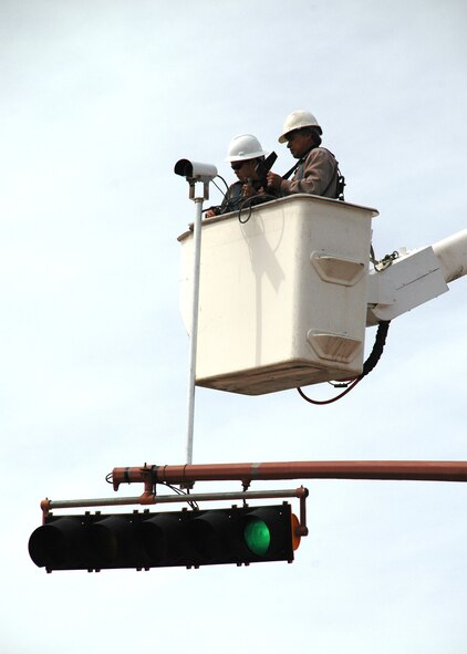 Senior Airman Brandi Holguin, 49th Civil Engineer Squadron, and Mr. Richard Estrada, 49 CES, synchronize the cameras to the traffic lights on First Street March 5. (U.S. Air Force photo by Airman Jamal Sutter)