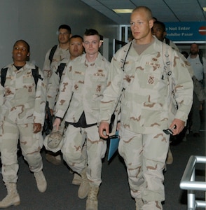 Airmen from the 37th Security Forces Squadron assigned to Lackland Air Force Base, Texas, make their way toward baggage claim and their waiting families March 5 at the San Antonio International Airport. Twenty-seven members of the squadron arrived home Monday morning after spending nearly nine months in Iraq conducting detainee operations for captured terrorist insurgents. (USAF photo by Alan Boedeker)                           