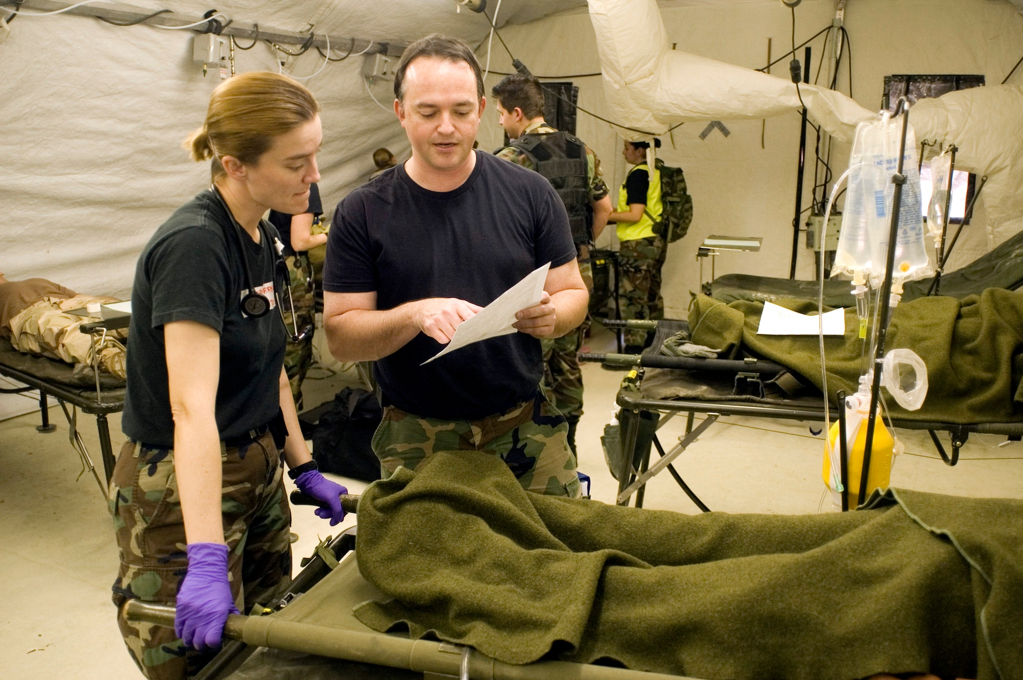 Expeditionary Medical Support student Capt. (Dr.) Laurie Marbas reviews critical patient information Feb. 22 with Critical Care Air Transport Team student, Maj. (Dr.) Stephen Reich prior to transferring the patient. By combining EMEDS and CCATT training, students experience handling patients from triage through transportation from a field hospital back to the states. (U.S.Air Force photo/Steve Thurow) 