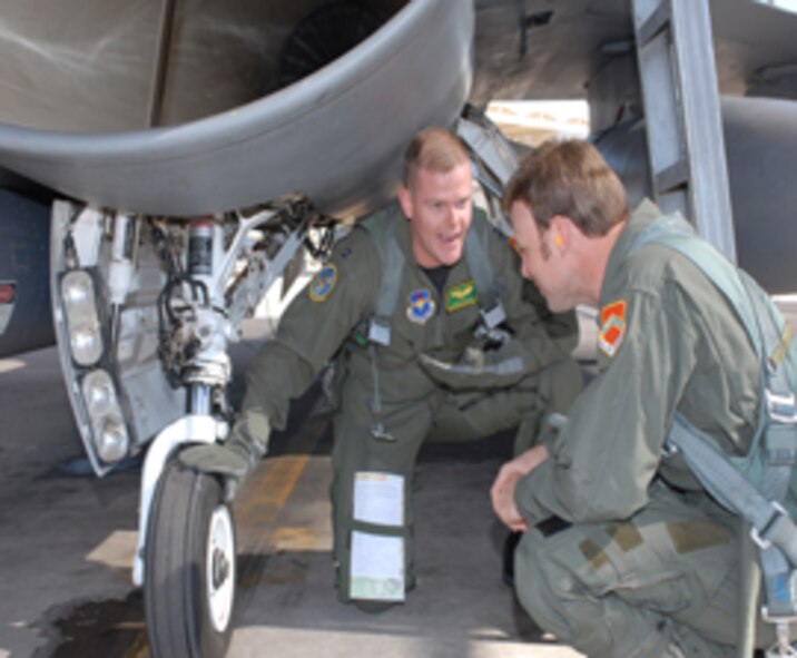 Capt. Chris Hansen, 310th Fighter Squadron instructor pilot, explains F-16 landing gear functions to Matt Kenseth, 12th place NASCAR driver, Feb. 22. Kenseth experienced the speed of anF-16 when Captain Hansen took him for a spin after signingautographs and speaking to members of the Luke communityat a Salute to Military Families event. (Photo by Senior Airman Christopher Hummel)