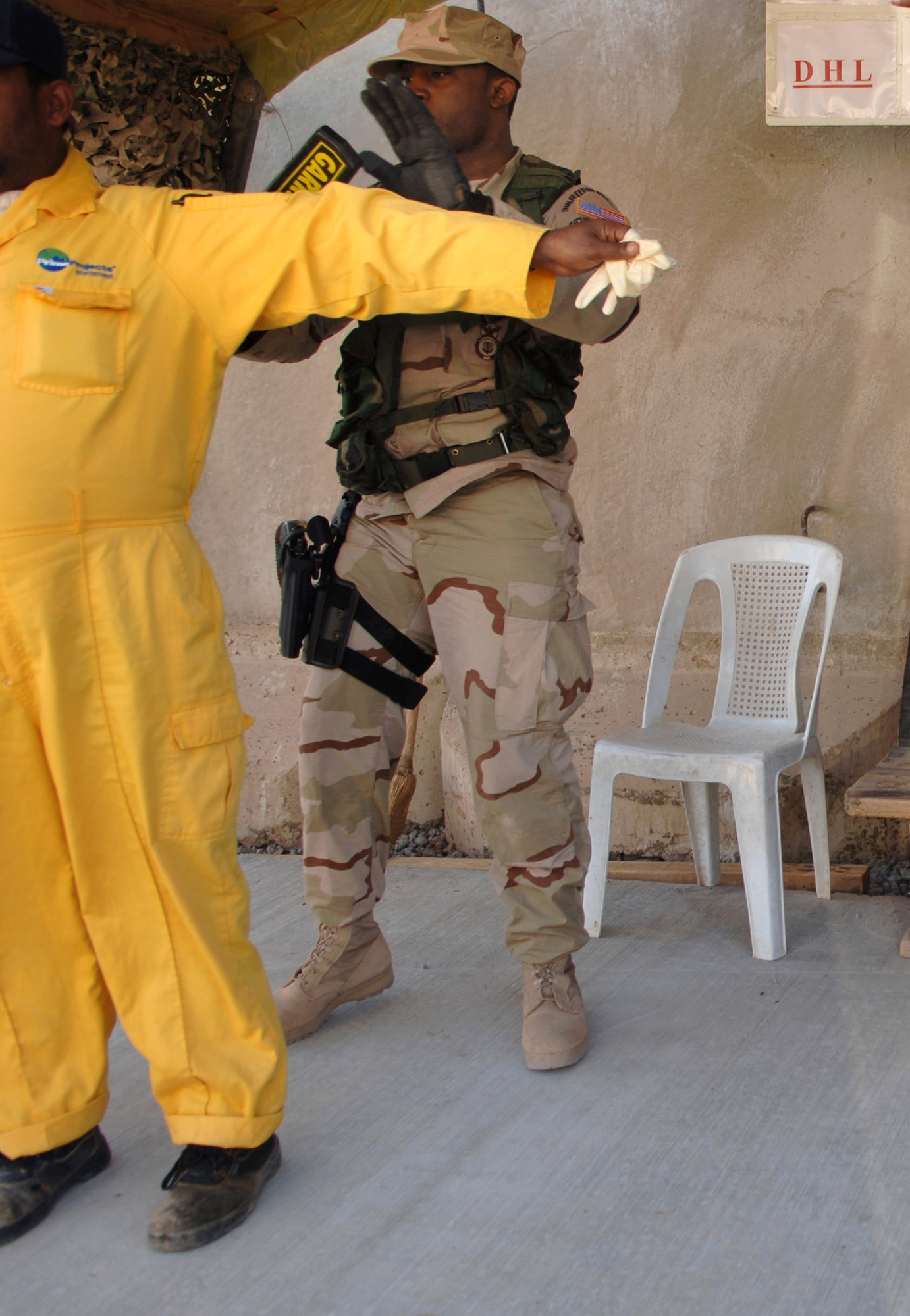 Airman 1st Class Marquis Garvin uses a metal detector to check a third-country national contractor for illegal items such as cameras and weapons Feb. 21 at Balad Air Base, Iraq. Airman Garvin is assigned to the 332nd Expeditionary Security Forces Squadron. (U.S. Air Force photo/Staff Sgt. Michael R. Holzworth) 