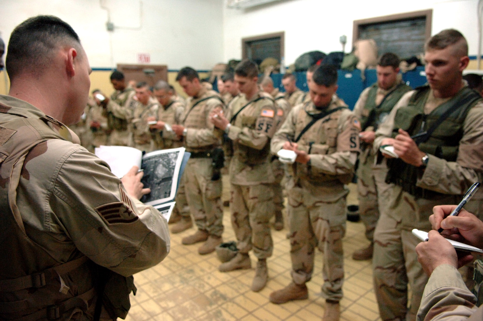Technical Sgt. Kenneth Prendergast gives a local intelligence briefing to security forces Airmen who write down important information during guardmount Feb. 15 at Balad Air Base, Iraq. Sergeant Prendergast is assigned to the 332nd Expeditionary Security Forces Squadron. (U.S. Air Force photo/Staff Sgt. Michael R. Holzworth)