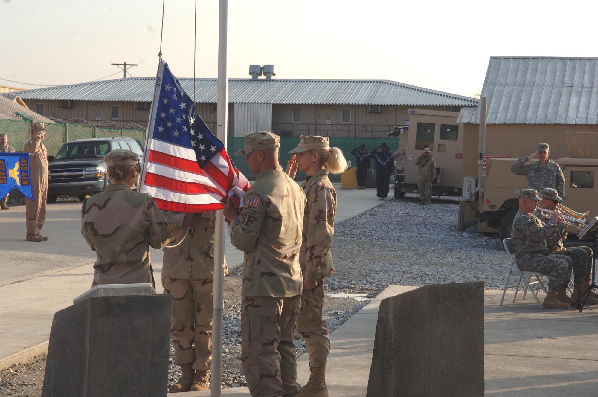 An honor guard from the 455th Air Expeditionary Wing takes down the American flag during a formal retreat ceremony at Camp Cunningham. The camp is named after Senior Airman Jason Cunningham, one of 20 Airmen to die in Afghanistan since 2001. (U.S. Air Force photo/Capt. Travis B. Tougaw)
