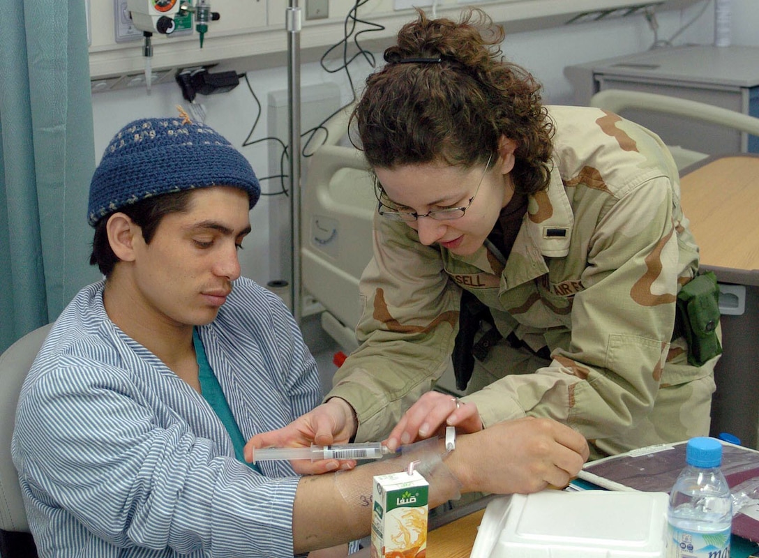 First Lt. Karis Russell, a nurse at Bagram Air Base, Afghanistan, flushes the intravenous line of Rahmat Shah, a patient at Craig Joint Theater Hospital on March. 4. Patients were moved from the base’s previous hospital to the new facility earlier that day. Photo by Staff Sgt. Thomas J. Doscher, USAF