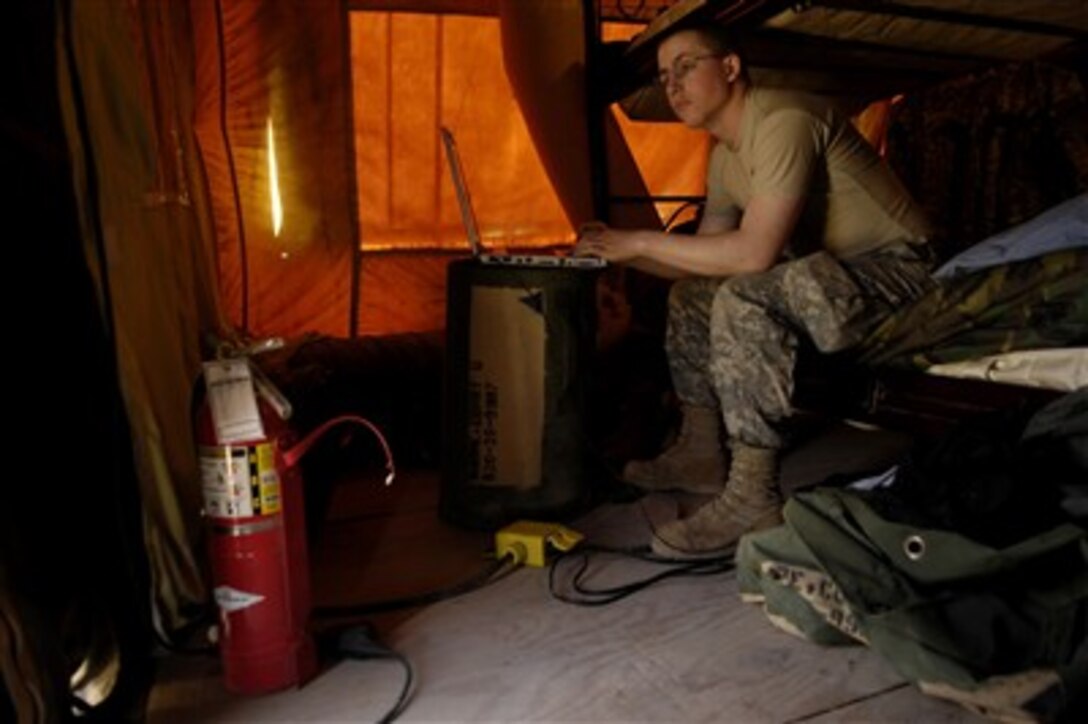 U.S. Army Spc. Corky Moore plays a game on his laptop during some down time at Forward Operating Base Warrior, Iraq, on March 3, 2007.  Moore is assigned to the 3rd Platoon, 300th Field Artillery.  