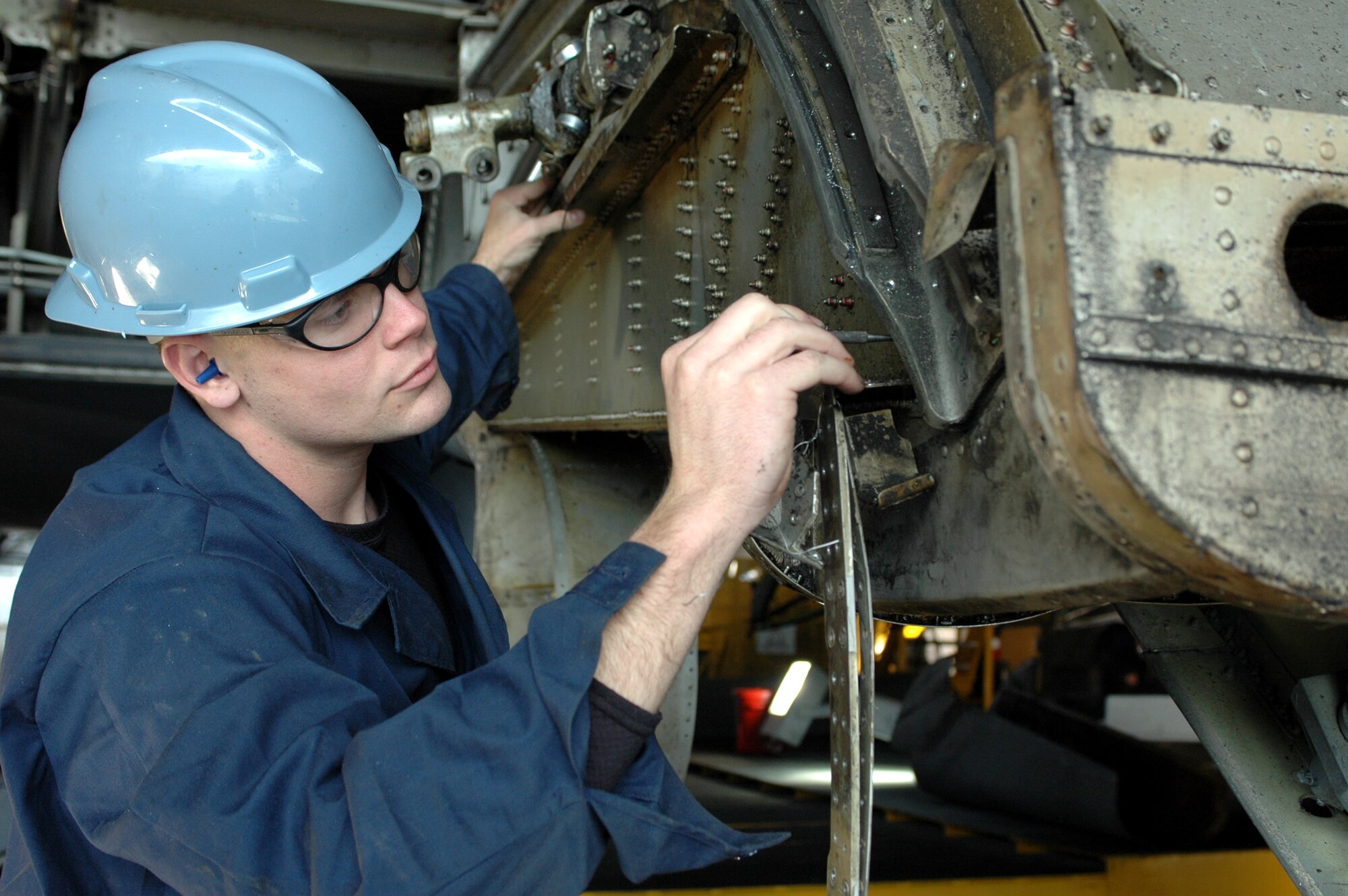 Airman 1st Class James Griffith, 60th Equipment Maintenance Squadron fabrication sheet metal technician, inspects each individual screw on a wing flap section of a C-5 Globemaster III. This tedious task is part of the Isochronal inspection performed every 420 days on the aircraft. The 60th EMS recently won the 2006 Air Mobility Command’s Maintenance Effectiveness Award. (U.S. Air Force photo by Tech. Sgt. Donald Osborn)
