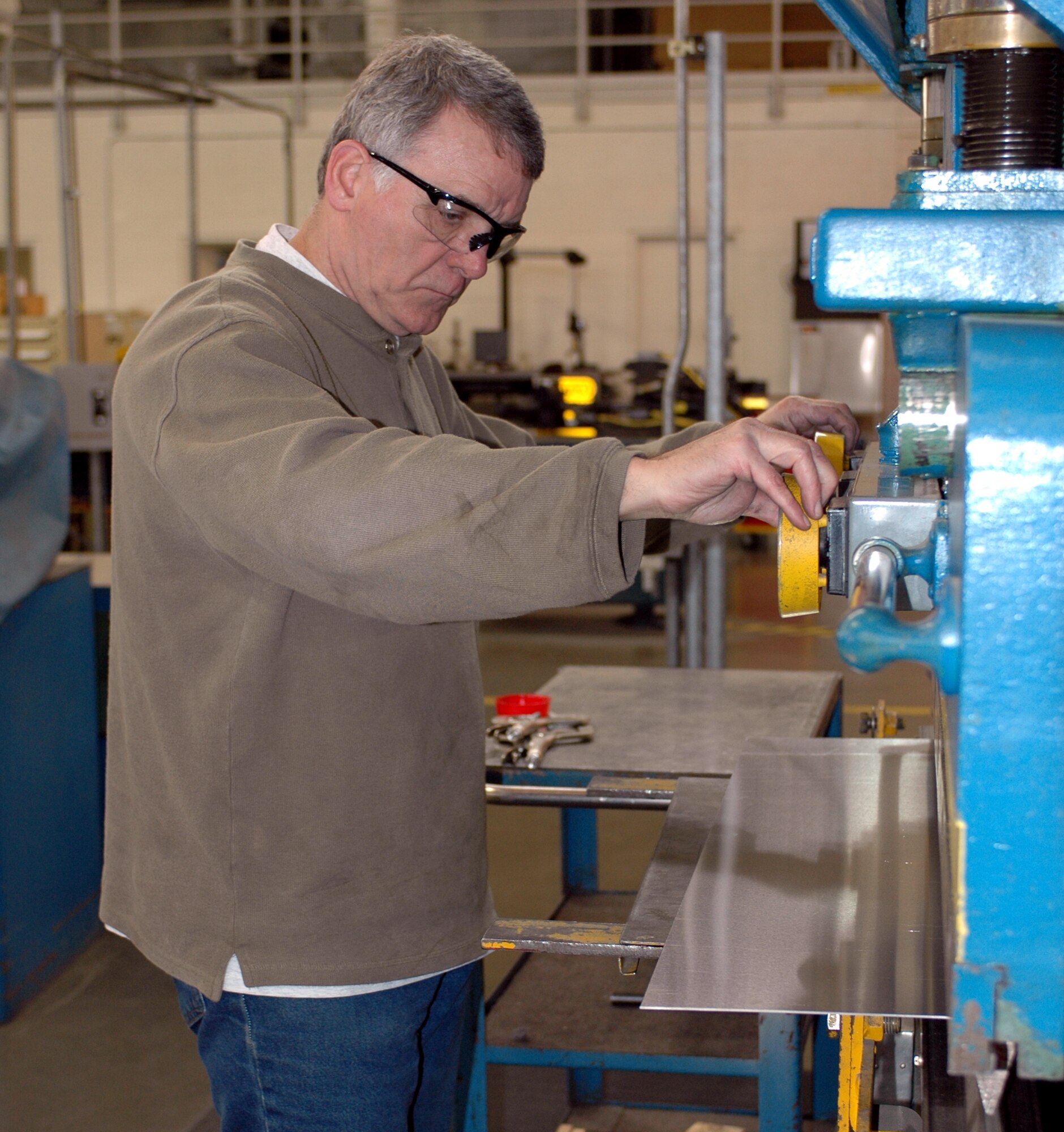 Mr. David Veno, 60th Equipment Maintenance Squadron template fabricator, uses a metal bender machine to methodically shape metal sheets into useable parts for Travis’ aircraft. The 60th EMS recently won Air Mobility Command’s Maintenance Effectiveness Award for 2006.  (U.S. Air Force photo by Tech. Sgt. Donald Osborn)