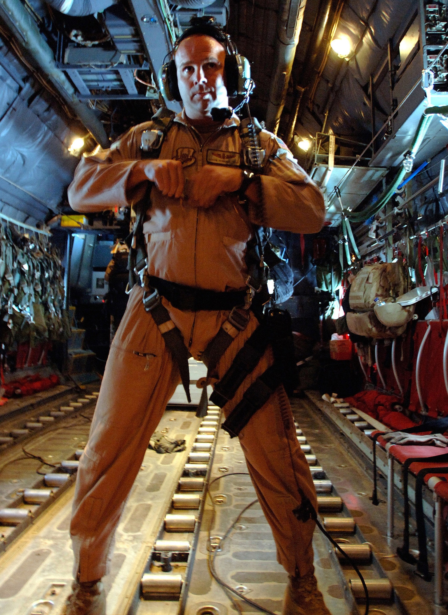 Tech. Sgt. Aaron Jennings, a C-130 Hercules loadmaster, locks his harness March 6 in preparation to drop 30,000 warning leaflets over the southern mountains of Afghanistan. The leaflet airdrop mission is contributing to Operation Achilles, launched March 6 by International Security Assistance Force, to create an environment that will enable the government of Afghanistan to help improve security and the Afghan people's quality of life. (U.S. Air Force photo/Tech. Sgt. Cecilio Ricardo) 
