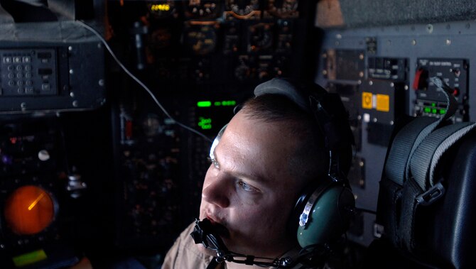 Captain Tim Romin, a C-130 Hercules aircraft navigator, coordinates mission maneuvers with his crew March 6 before dropping 30,000 warning leaflets over the southeastern mountains of Afghanistan. The leaflet airdrop mission is contributing to Operation Achilles launched by International Security Assistance Force to help improve security and the Afghan people's quality of life. (U.S. Air Force photo/Tech. Sgt. Cecilio Ricardo) 