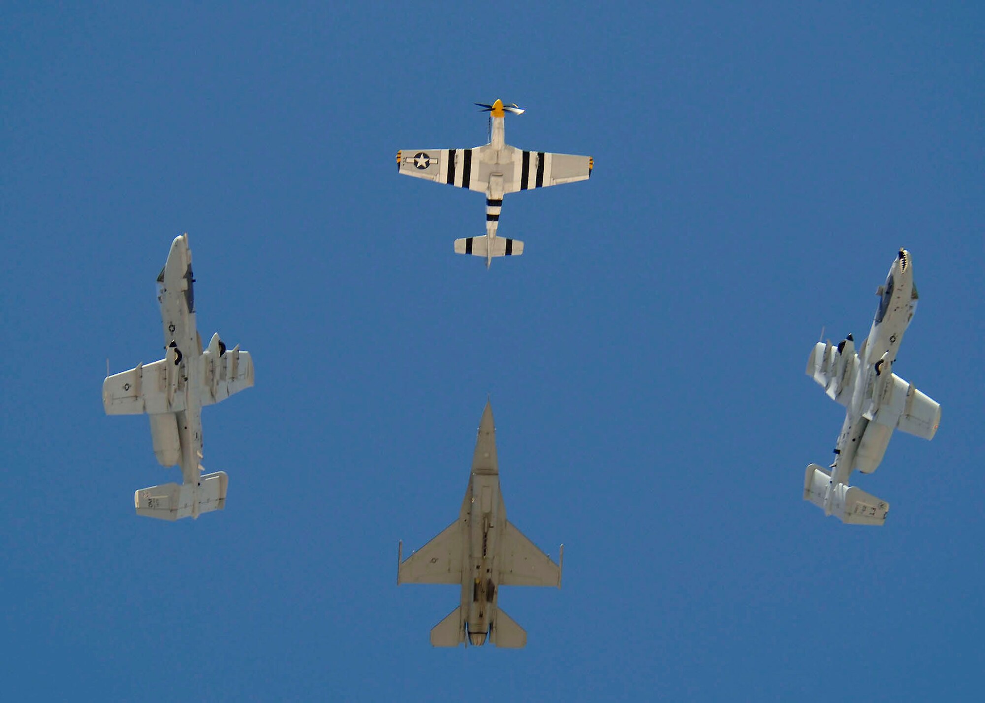 Two A-10 Thunderbolt IIs break away from their formation as a P-51 Mustang and an F-16 Fighting Falcon continue on March 3 while demonstrating aerial capabilities during the 2007 Heritage Conference at Davis-Monthan Air Force Base, Ariz.  The conference provides an opportunity for Air Combat Command demonstration pilots to train together with modern and historic military aircraft in preparation for the upcoming air-show season.  (U.S. Air Force photo/Senior Airman Christina D. Ponte)