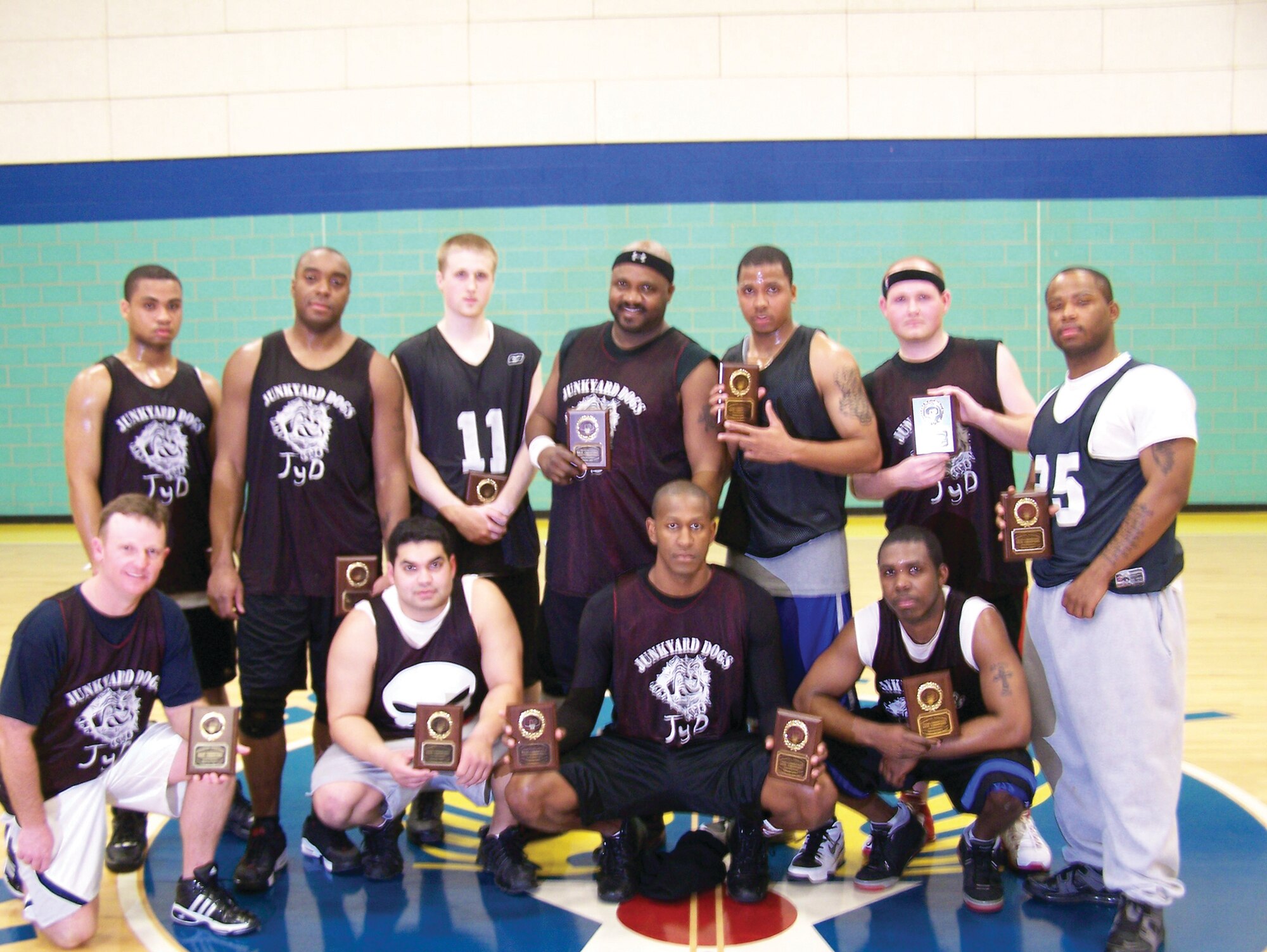 Members of the 17th Mission Support Group Junk Yard Dogs pose for a group photo after winning the 2006-2007 Goodfellow Basketball Championship versus the1st Responders Feb. 16 at the Mathis Sports and Fitness Center gymnasium. Back row (from left to right): Laverne Jackson, Bryan Samuel, David Cucuzzi, Bo Westbrooks, Mike Thompson, Brian Stansbury and Darryl Parker. Front row (from left to right): Douglas Hennen, Omar Matos, Brian Williams (Coach) and Antwain Gooding, Players Joshua Swisher and Brian Henry and Coach Aaron Lemke were not available for photo. (U.S. Air Force photo by Tech. Sgt. Thelma Soltero)