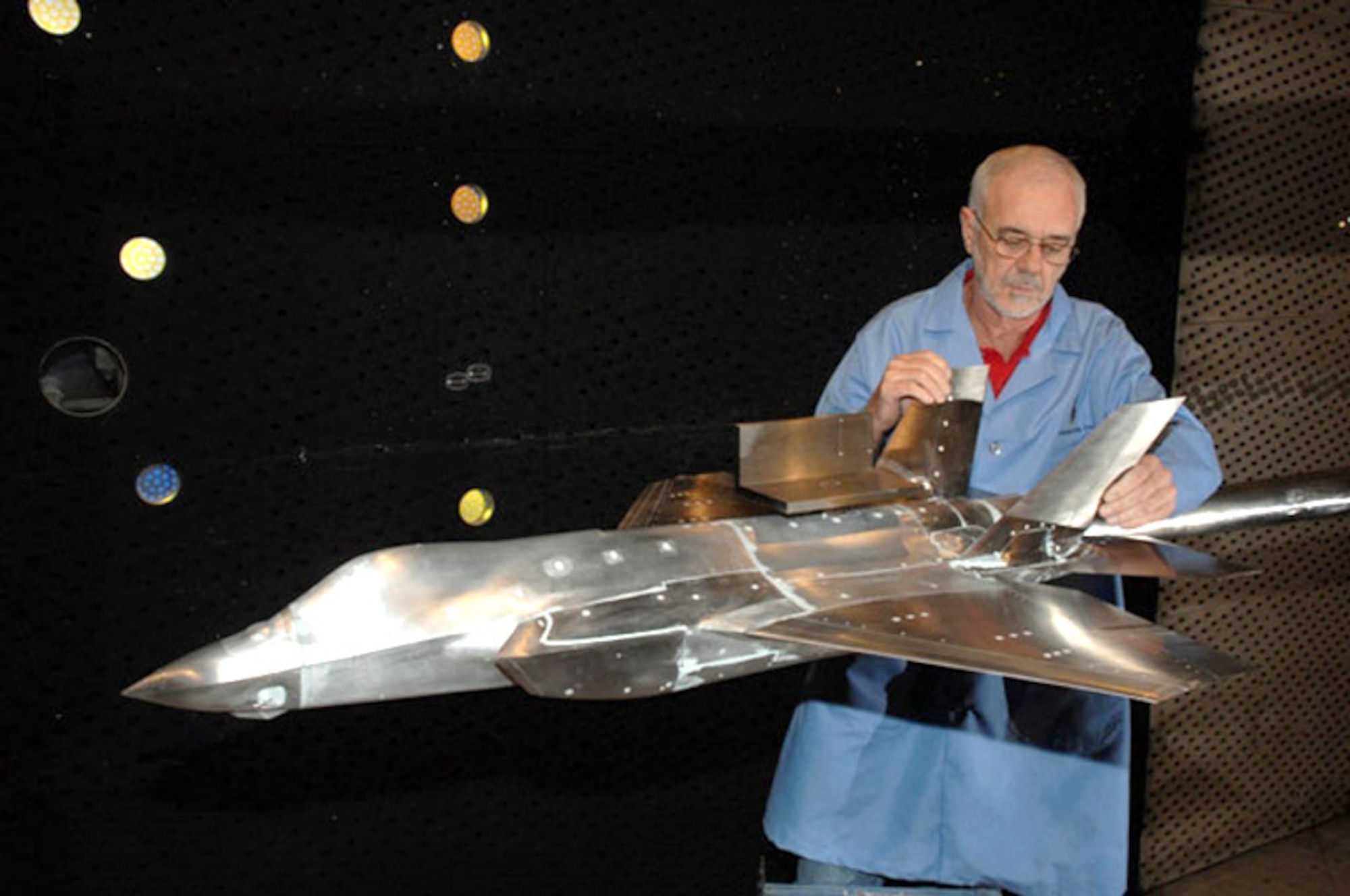 Carey Wofford checks the movement of the vertical stabilizers of an F-35 Lightning II joint strike fighter test model at Arnold Engineering Development Center, Arnold Air Force Base, Tenn., during a model change prior to resuming an aerodynamics test.  Mr. Wofford is an Aerospace Testing Alliance outside machinist.  (U.S. Air Force photo/Rick Goodfriend)