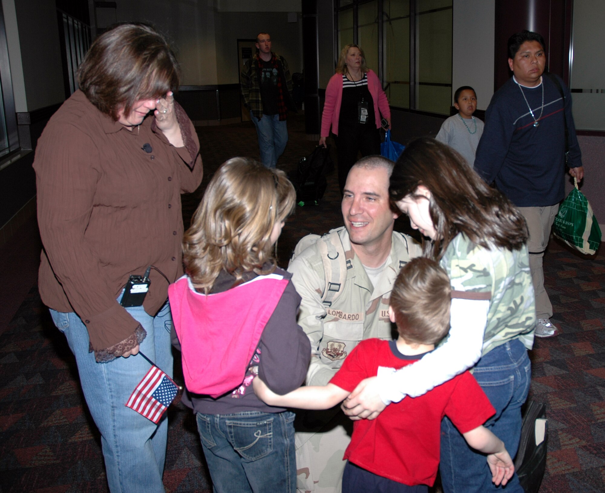 Capt. Kevin Lombardo, operations officer for the 21st Security Forces Squadron, receives an emotional welcome home by his wife and children March 5, at the Colorado Springs Airport. Captain Lombardo is one of five security forces members returning home after an eight month deployment to Iraq. “It’s absolutely incredible to be home,” he said. (U. S. Air Force photo by Tech. Sgt. Matt Gilreath)
