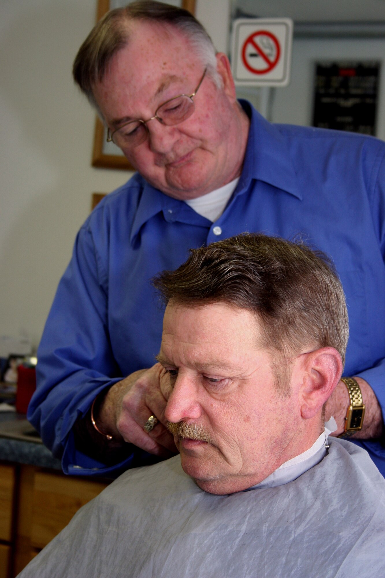 GRISSOM AIR RESERVE BASE, Ind.--Tech. Sgt. Bill Whitcomb, an electrical power productions technician at the 434th Civil Engineering Squadron, takes time, during his lunch break to maintain Air Force apperance standards at the Base Barber Shop. Bill Hartzler, a civilian barber, has been serving Grissom personnel for 34 years. (U.S. Air Force photo/Senior Airman Omar Delacruz)
