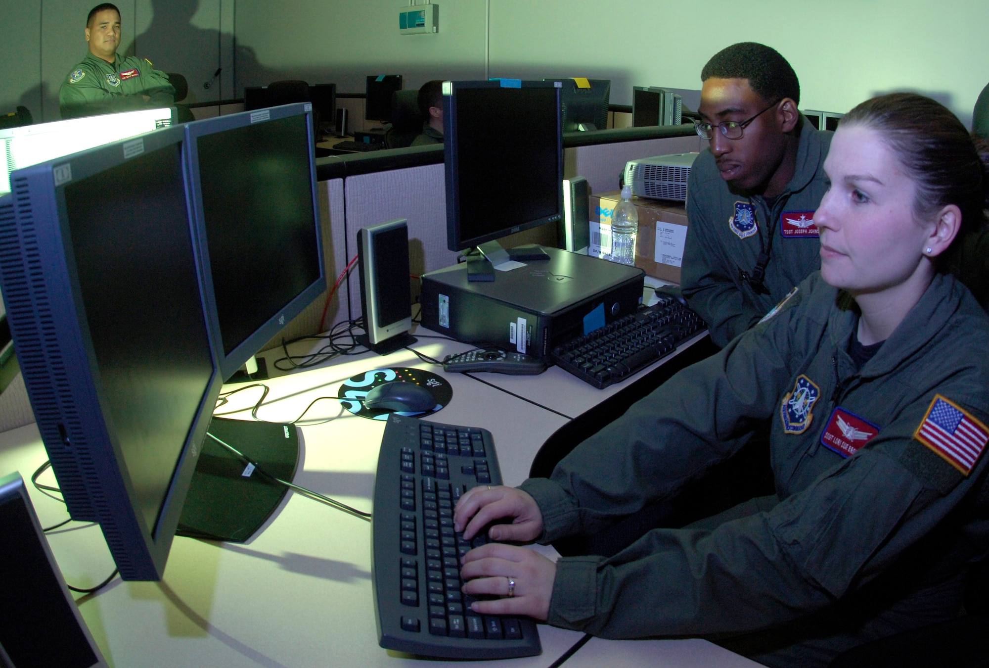 Staff Sgt. Lori Sue Browning and Tech. Sgt. Joseph Johnson discuss a problem while training at the Space Based Infrared Systems Mission Control Station training Detachment 1 of the 460th Operations Group located at Schriever Air Force Base, Colo. (U.S. Air Force photo/Senior Airman Javier Cruz Jr.) 
