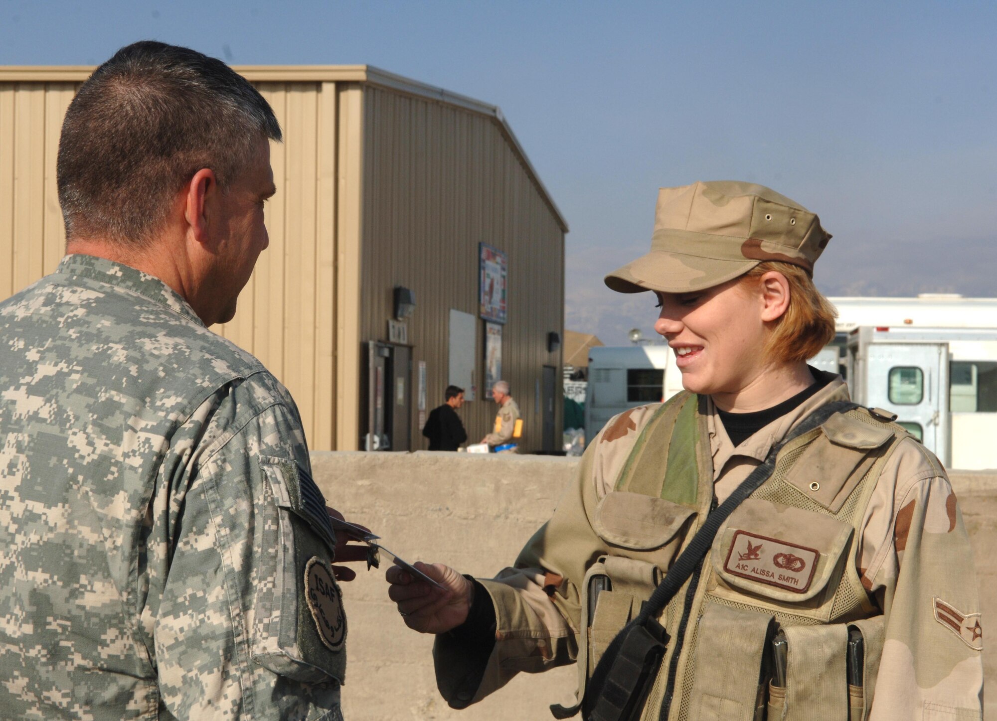 Airman 1st Class Alissa Smith of the 455th Expeditionary Security Forces Squadron checks identification of a soldier at an entry control point. (U.S. Air Force photo by Staff Sgt. Kevin Tomko)