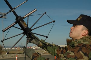 Air Force Reservist Tech. Sgt. David Salvador, 940th Communications Flight secure communications specialist, adjusts an antenna prior to establishing a satellite communication link during training March 3, 2007 at Beale Air Force Base, Calif.  The satellite radio equipment provides both secure and unsecure voice and data capability. (U.S. Air Force photo/Stacey Knott)  
